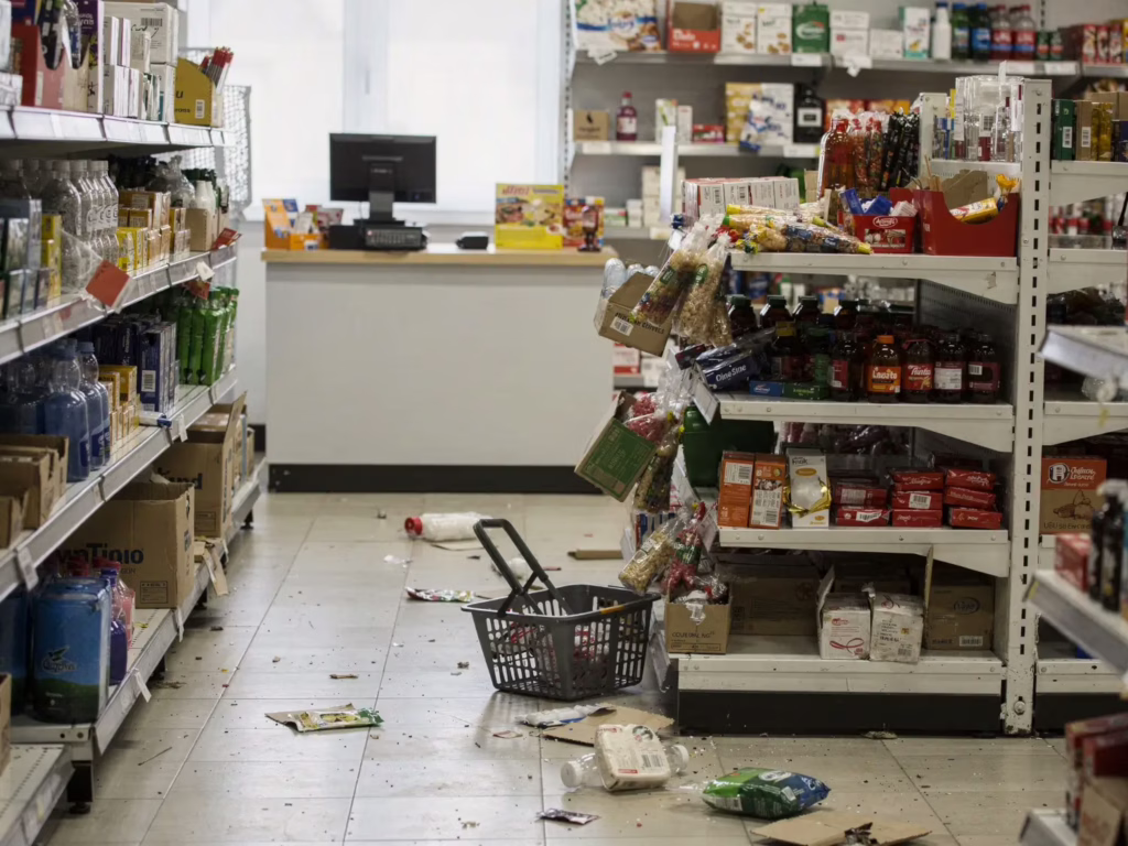 Retail store interior left slightly disorganized after an incident with items scattered on the floor, showing lack of on-site security presence.